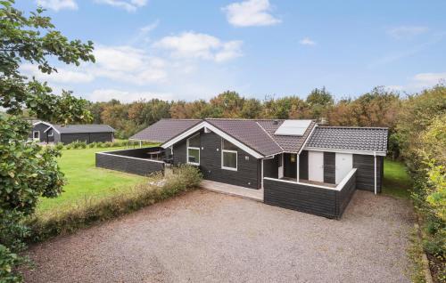 a black and white house with a yard at Awesome Home In Hemmet With Sauna in Hemmet