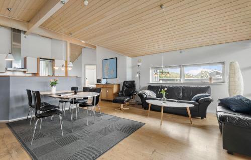 a living room with a couch and a table and chairs at Awesome Home In Hemmet With Sauna in Hemmet