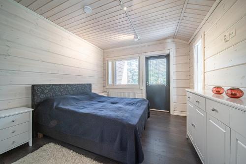 a bedroom with a bed in a room with wooden walls at Levillas koutakaari 6B in Levi