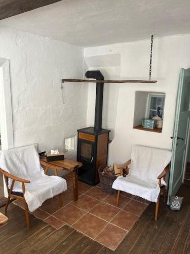 a living room with two chairs and a wood stove at Chalupa Bělčice in Bělčice