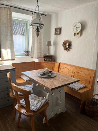 a dining room with a table and chairs and a clock at Chalupa Bělčice in Bělčice