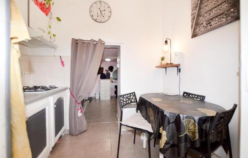 a kitchen with a table and chairs and a clock on the wall at Lovely Home In Peri With Wifi in Peri