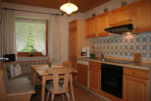 a kitchen with wooden cabinets and a table and a window at Haus Auzinger in Schönau am Königssee