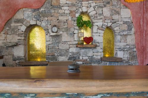 a stone wall with three windows and a table at LiveTulum in Tulum