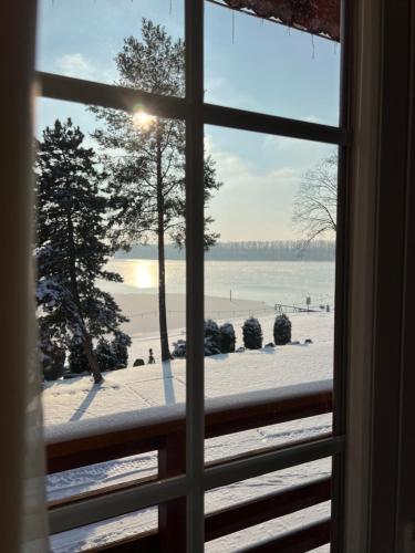 a window with a view of a beach in the snow at Resort Maják in Horní Soběšovice