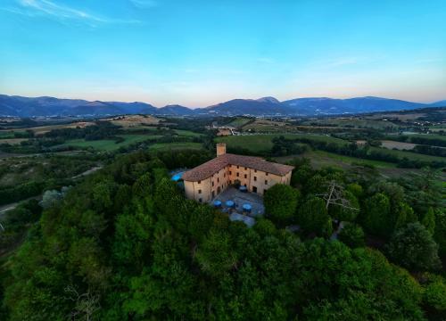an aerial view of a house on a hill with trees at Castello di Baccaresca in Branca
