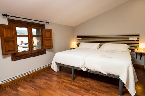a bedroom with a bed and a window at Paratene Ostatu Habitaciones in Erandio