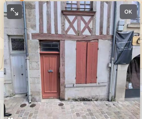 a building with red doors on the side of it at Glycine in Orléans