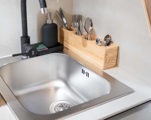 a kitchen sink with a knife block and utensils at Amatera Luxury Apartments in Matera