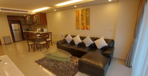 a living room with a leather couch and a table at City Garden Pattaya - 2br Suite, 76sqm in Pattaya