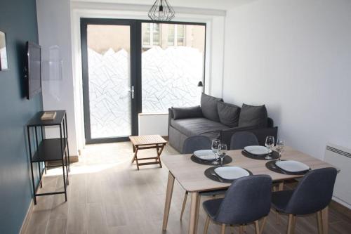 un salon avec une table, des chaises et un canapé dans l'établissement Charmant T2 à 2 pas du centre-ville et du marché de Talensac, à Nantes