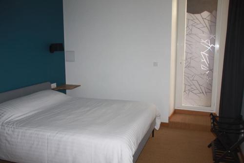 une chambre avec un lit blanc et une fenêtre dans l'établissement Charmant T2 à 2 pas du centre-ville et du marché de Talensac, à Nantes