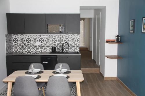 une cuisine avec une table et des chaises dans une pièce dans l'établissement Charmant T2 à 2 pas du centre-ville et du marché de Talensac, à Nantes
