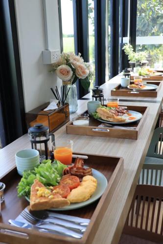 a long wooden table with plates of food on it at Fulfield Cafe&Resort in Ban Nong Saeng Sa-at