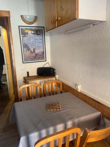 une table et des chaises dans une cuisine avec une table et une table dans l'établissement Tignes - Studio rénové pour 3 personnes, à Tignes
