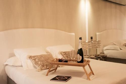 Una cama con una mesa con una botella de vino. en Love room Dubaï & Balnéo, en Saint-Rambert-d'Albon