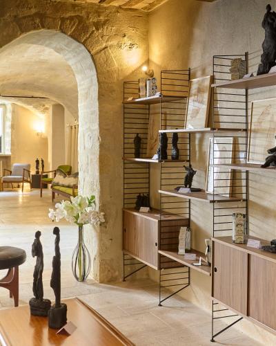 a room with a wall of shelves with vases at Boutique Hôtel Entraigues in Uzès