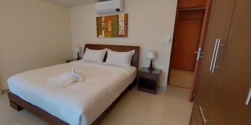 a bedroom with a bed with white sheets and pillows at City Garden Pattaya - 2br Suite, 76sqm in Pattaya