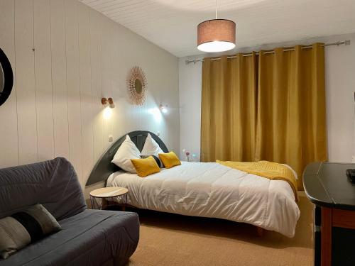 - une chambre avec un lit doté d'oreillers jaunes et d'un canapé dans l'établissement Résidence Orphé A, à Saint-Jean-de-Monts