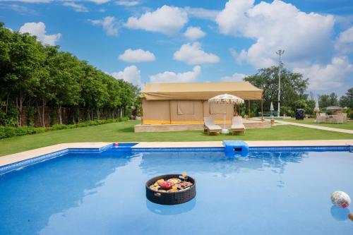 a bowl of fruit in a basket in a swimming pool at Elivaas 5 BHK with Pool, Tents & Pond - Kaimalgarh Farmstay in Bhundsi
