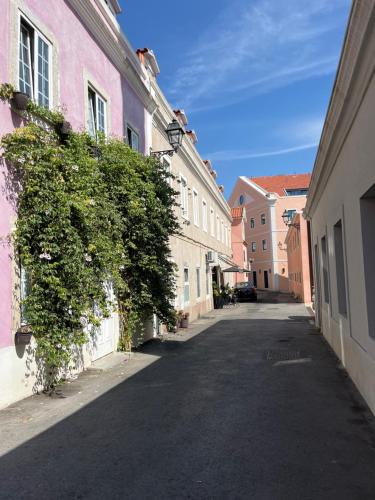 una strada vuota in una città con edifici rosa di Casa Cor de Rosa a Lisbona