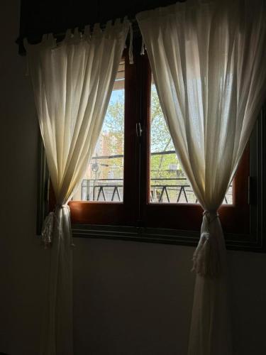 a window with white curtains in a room at Departamento en junin in Junín
