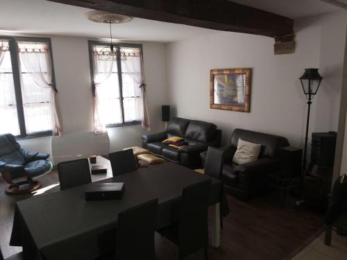 un salon avec une table et des chaises noires dans l'établissement Grande maison de ville au centre Saint Aignan, à Saint-Aignan