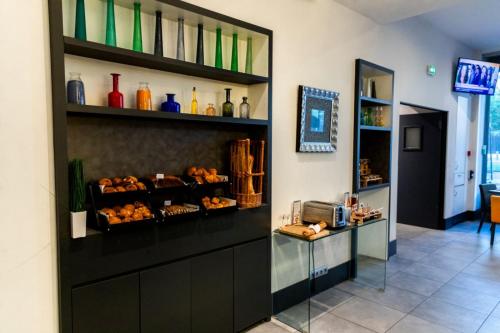 a room with a counter with a bunch of food at Porte de Versailles Hotel in Paris