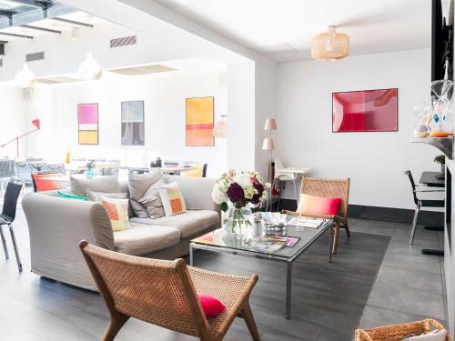 a living room with a couch and a table at Porte de Versailles Hotel in Paris