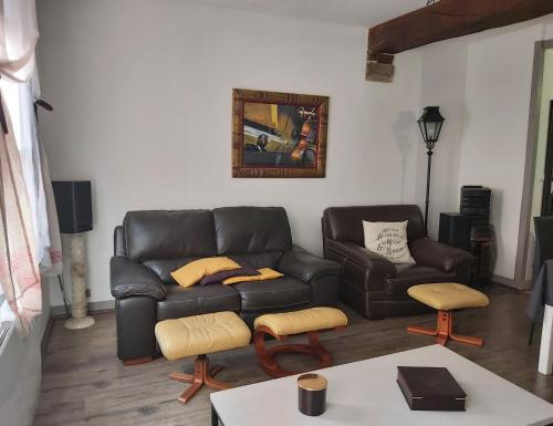 un salon avec un canapé en cuir et une table dans l'établissement Grande maison de ville au centre Saint Aignan, à Saint-Aignan