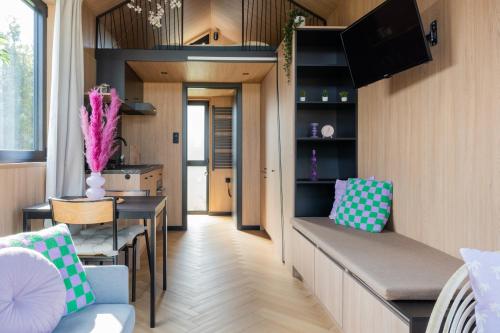 a living room with a couch and a table at Luxe tinyhouse 2 op minicamping in waarde in Waarde