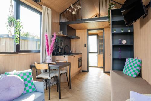 a kitchen and living room with a table and chairs at Luxe tinyhouse 2 op minicamping in waarde in Waarde