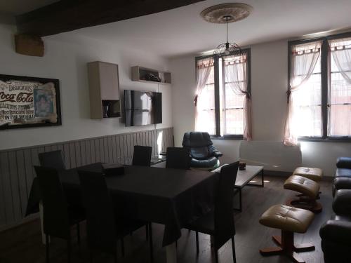 une salle à manger avec une table, des chaises et des fenêtres dans l'établissement Grande maison de ville au centre Saint Aignan, à Saint-Aignan