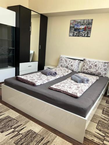 a bedroom with a bed with two pillows on it at Olympia Residence in Chişineu Criş