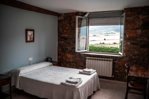 a small bedroom with a bed and a window at Agroturismo Biltegi Etxea in Alda