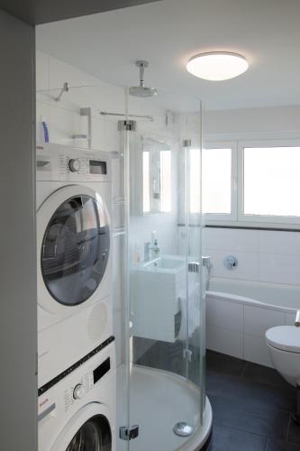 a white bathroom with a washing machine in a shower at #5 HQ Studio in bester Lage in Friedrichshafen