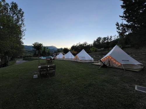 a row of tents in a grass field at Camping BOSQUE DE G0RD0N in La Pola de Gordón