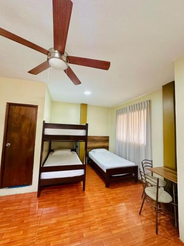 a bedroom with two bunk beds and a ceiling fan at Hotel Bolognesi Tumbes in Tumbes