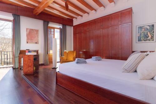 een slaapkamer met een groot bed en een houten muur bij Casa Colomer in Canet de Mar