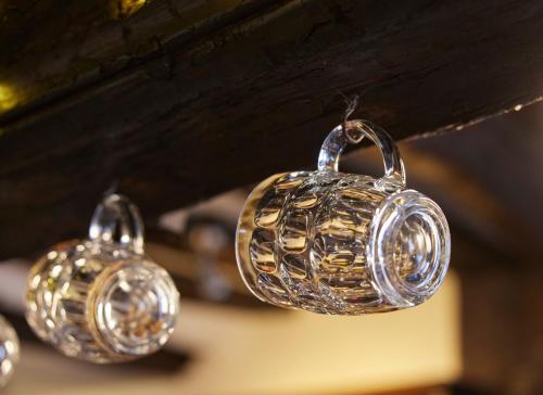 a group of silver bells hanging from a ceiling at Bull Hotel by Greene King Inns in Long Melford