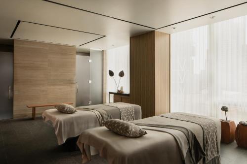 a hotel room with three beds and a window at Four Seasons Hotel Toronto in Toronto