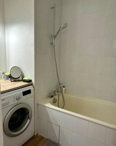 une salle de bain avec douche et machine à laver dans l'établissement Appart moderne, spacieux et lumineux, à Paris