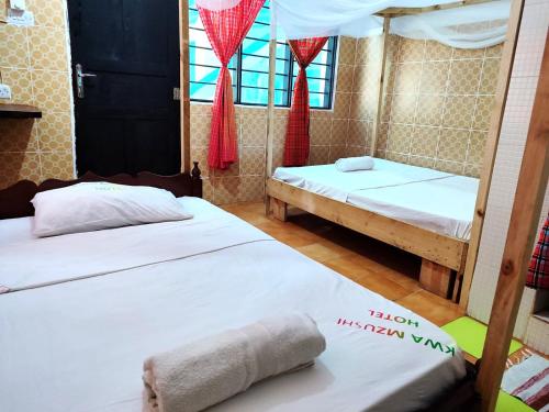 two beds in a room with red curtains at HOMELAND SWAHILI LODGE Nungwi Backpacker Apartments BUDGET in Nungwi
