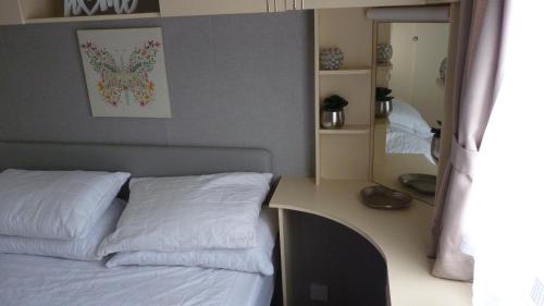 a bedroom with a bed and a desk with a mirror at L&g caravan hire 6 BERTH CORAL BEACH LAURA FAMILYS ONLY AND LEAD PERSON MUST BE OVER 30 in Ingoldmells