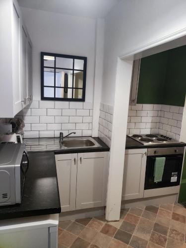 a kitchen with a sink and a window at The Old Bike Cabin Flat 1 in Heapey