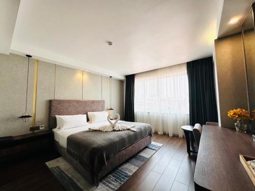 a hotel room with a bed and a table at Harmony Phnom Penh Hotel in Phnom Penh