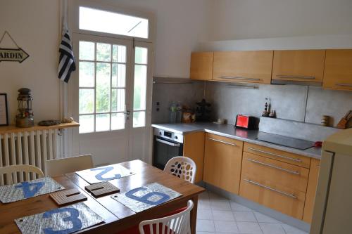 une cuisine avec une table en bois et une table ainsi qu'une salle à manger dans l'établissement Maison typiquement Malouine, à Saint-Malo