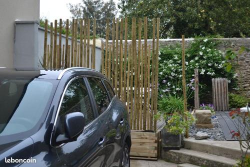 une voiture garée devant une clôture en bois dans l'établissement Maison typiquement Malouine, à Saint-Malo