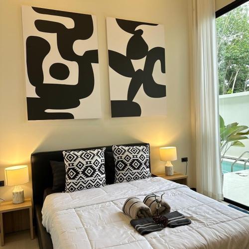 a bedroom with a bed with shoes on it at Villa Yu Pool Villa in Ban Muang Khom