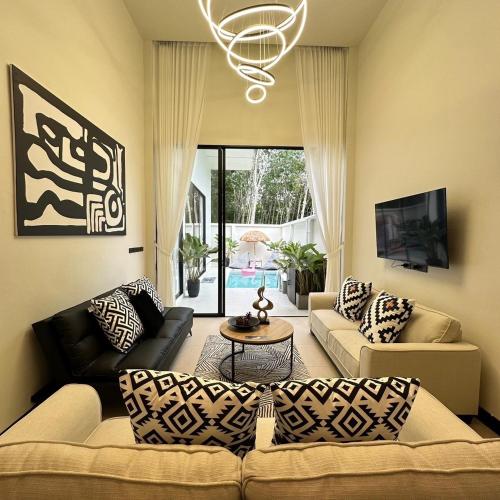 a living room with a couch and a table at Villa Yu Pool Villa in Ban Muang Khom